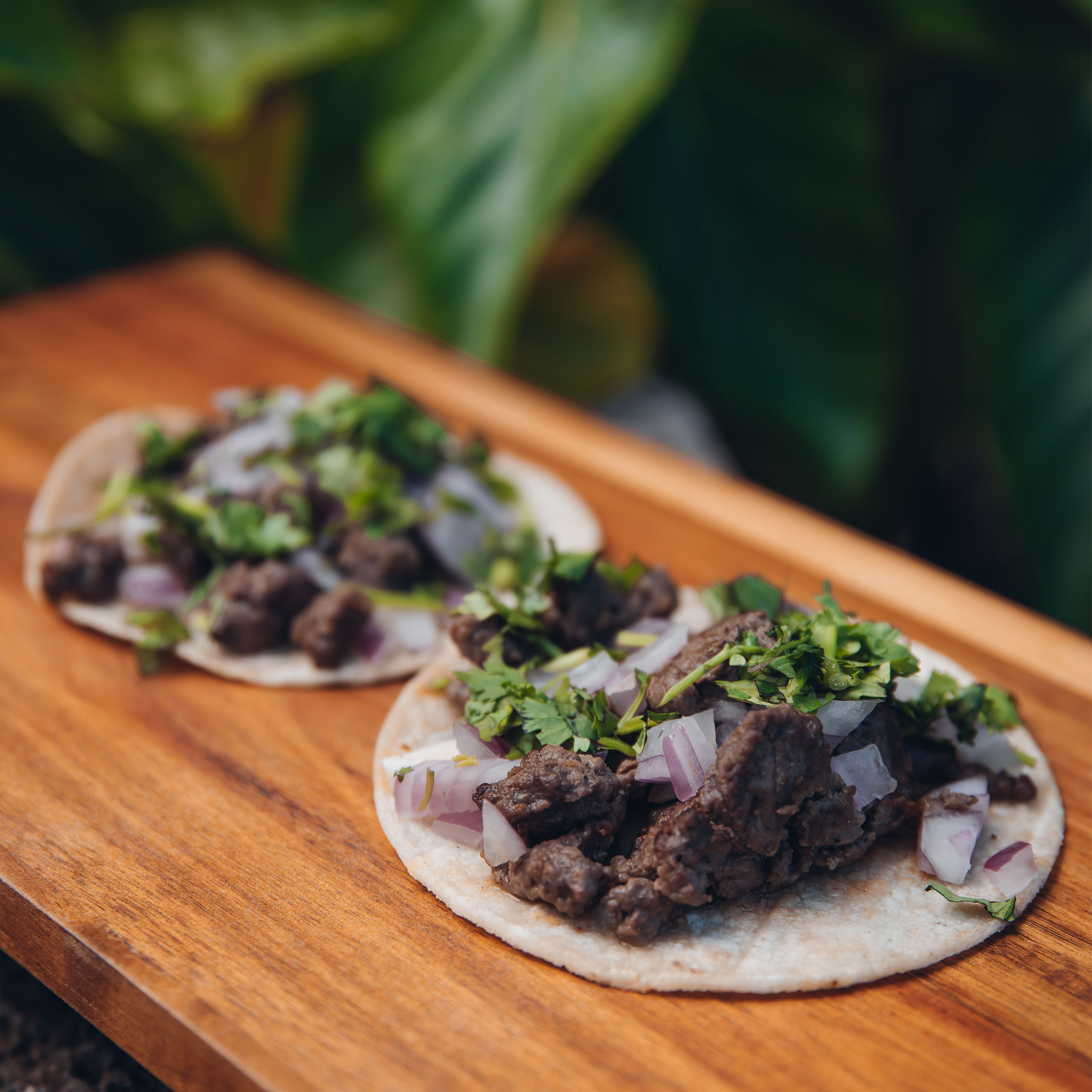 steak in the tacos with beef , onions and cilantro