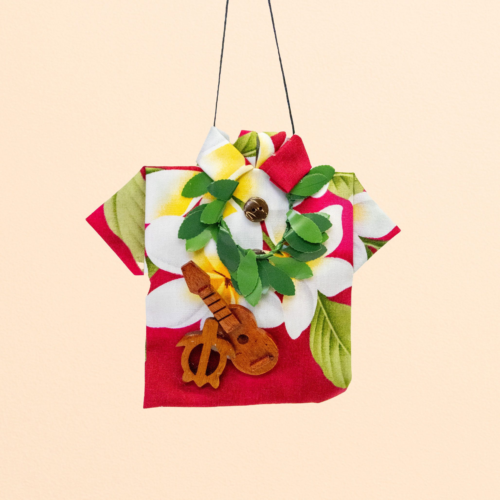 Christmas ornament shaped like a Hawaiian shirt with floral print, wreath, and small ukulele