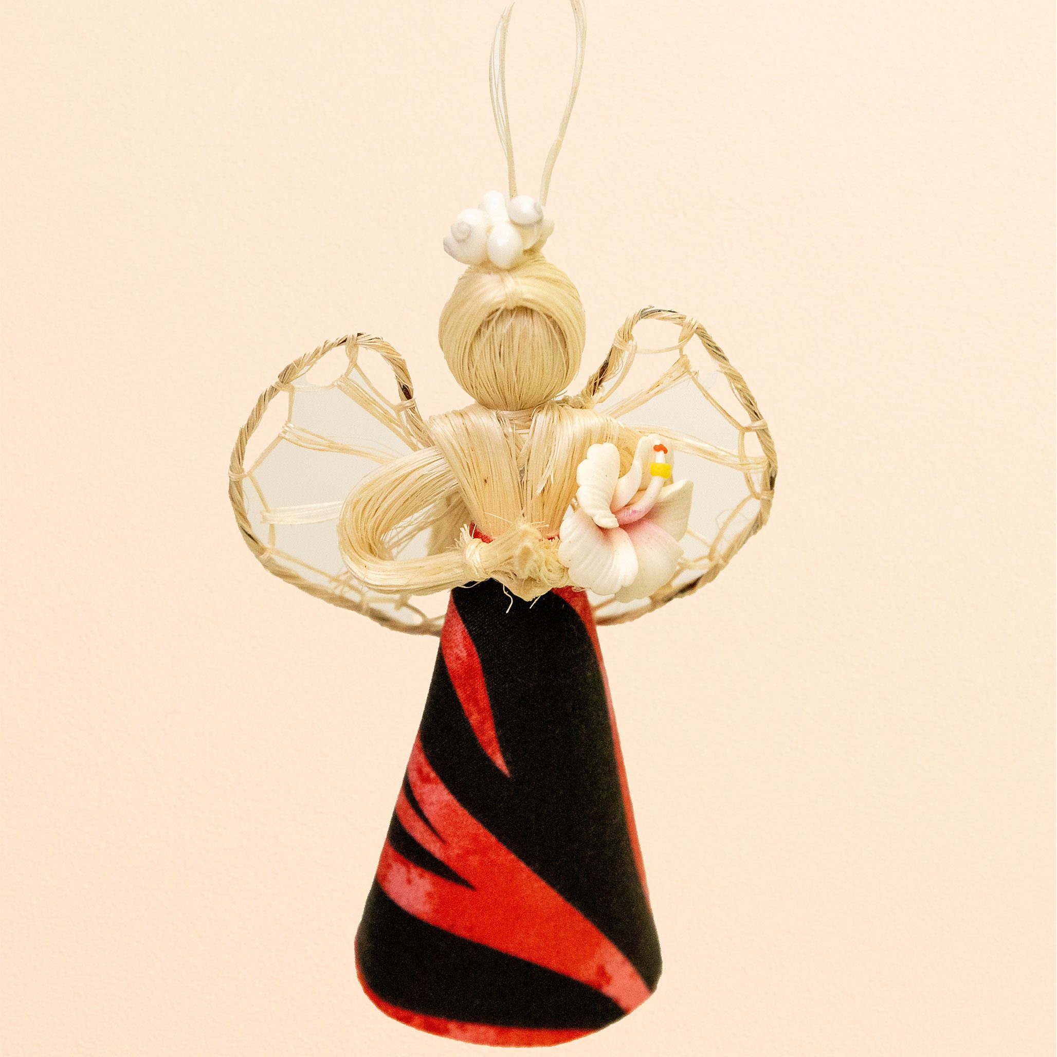 Handmade angel ornament with woven straw wings, red and black dress, and flower decoration