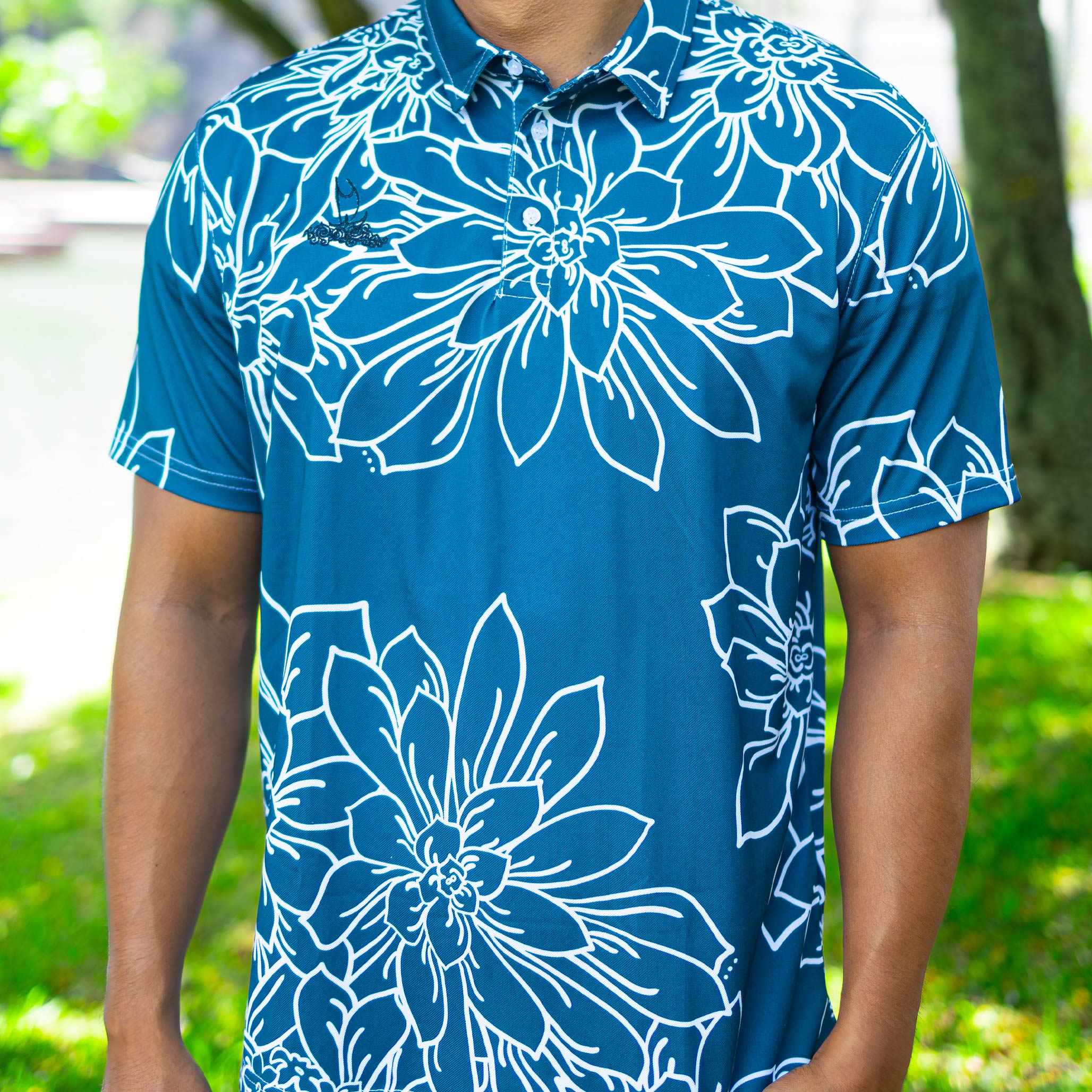 Man wearing a blue floral print polo shirt outdoors